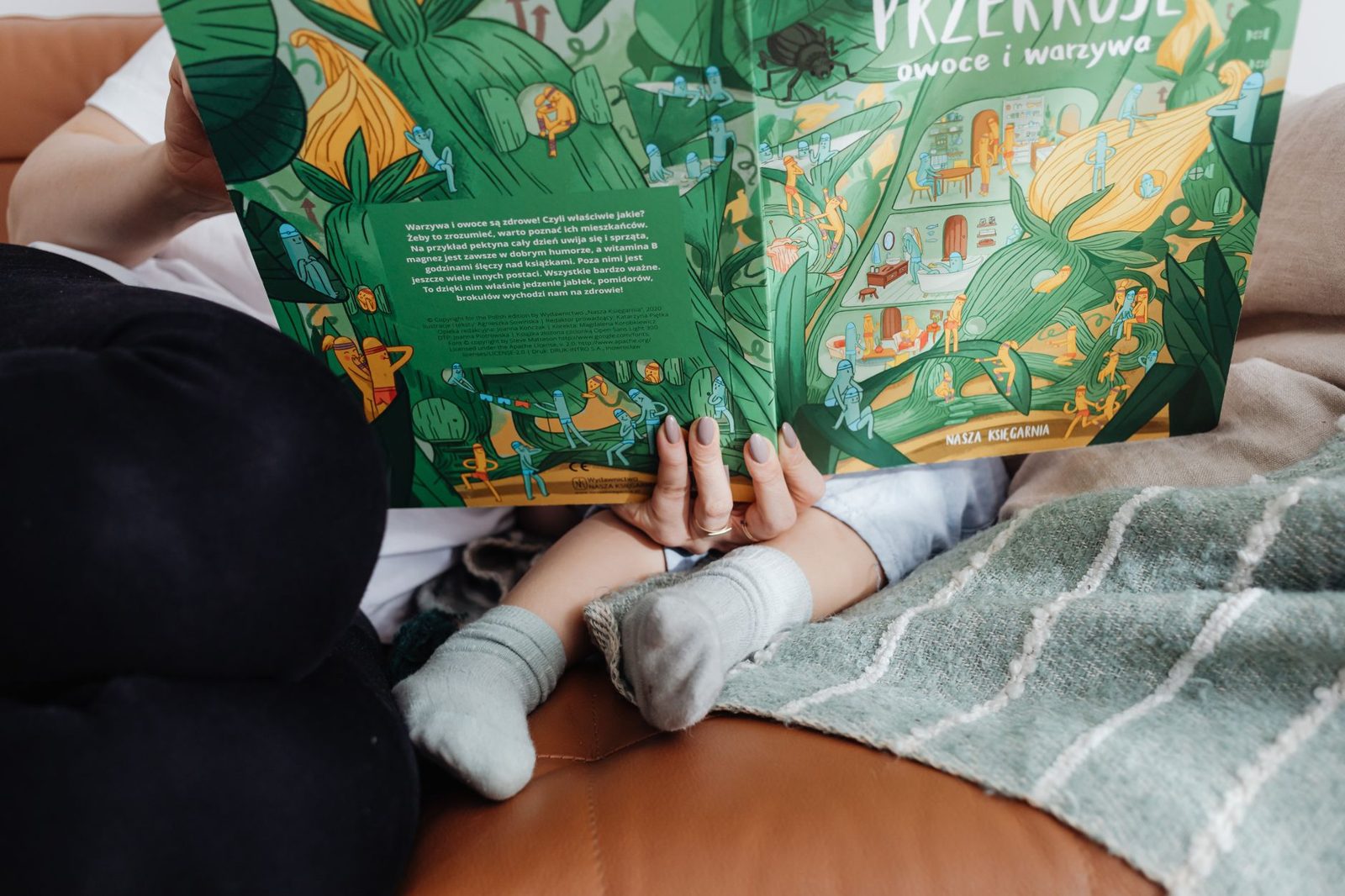 Manos hojeando un libro ilustrado de naturaleza en el rincón de lectura